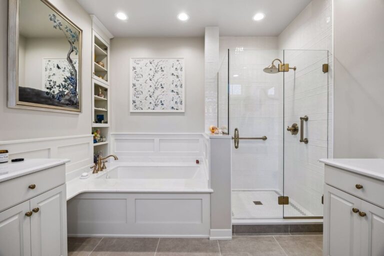 Spacious primary bathroom remodel in Golden Valley, MN featuring a soaking tub, glass shower, and brass fixtures.